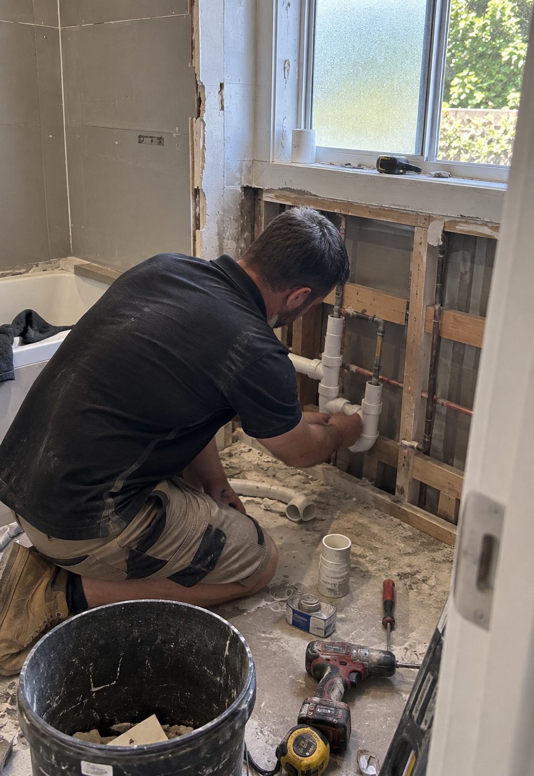 Plumber laying pipework during a bathroom renovation